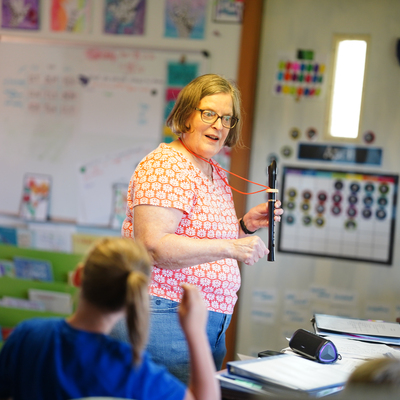Mrs. Thurn teaching music to the kids with recorders.